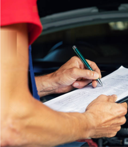 Techician writing on inspection sheet.